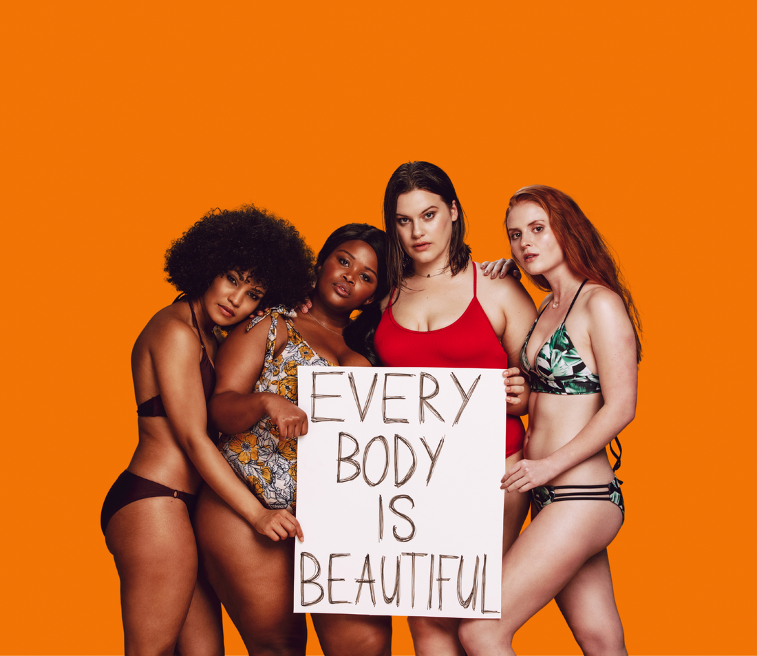 Vier Frauen unterschiedlicher Körpertypen in Bikinis halten gemeinsam ein Schild mit den Worten „Every body is beautiful“ hoch.